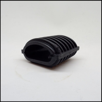 Peça preta de borracha ou plástico com ranhuras, sobre fundo branco