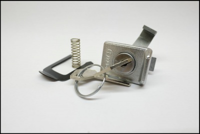 Cadeado metálico prateado com chave e mola em fundo branco