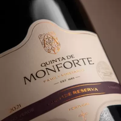 Garrafa de vinho tinto com rótulo creme e detalhes dourados