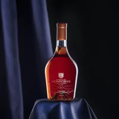 Garrafas de vinho âmbar com rótulo branco e texto sobre fundo preto