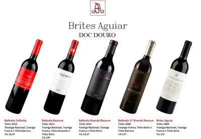 Cinco garrafas de vinho tinto Brites Aguiar e Bafarela com várias etiquetas coloridas e tampas diferentes.