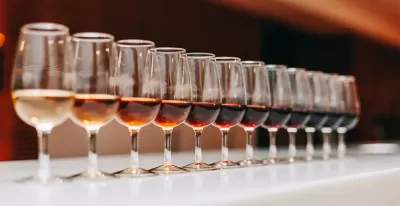 Dúzia de copos de vinho com diferentes tonalidades em fila