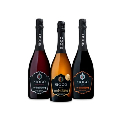 Três garrafas de espumante Miogo com rótulos diferentes em fundo branco