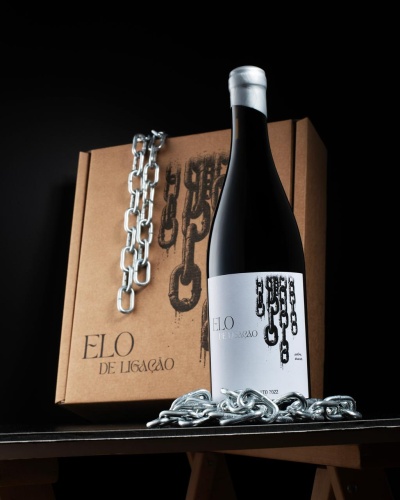 Garrafa de vinho tinto com etiqueta branca e caixa de cartão com design de correntes