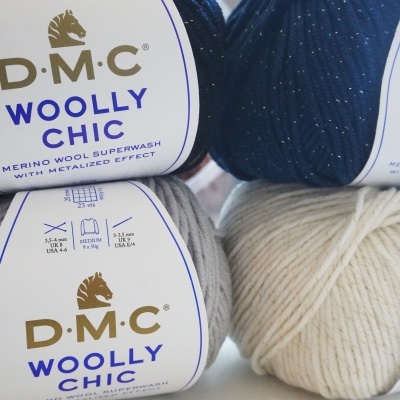 Quatro novelos de lã D.M.C Woolly Chic em azul escuro, cinzento e bege claro.
