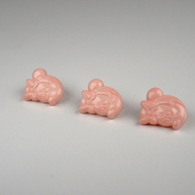 Três botões cor-de-rosa com rosto sorridente e laço em fundo branco