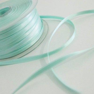 Rolo de fita de cetim azul claro parcialmente desenrolada