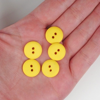 Cinco botões amarelos redondos na mão