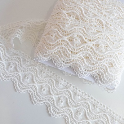Renda branca com padrão ondulado colocada sobre uma superfície clara