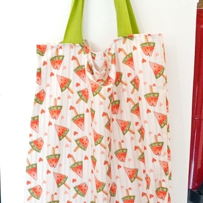 Sacos de tecido com padrão de melancia e alças verdes pendurados