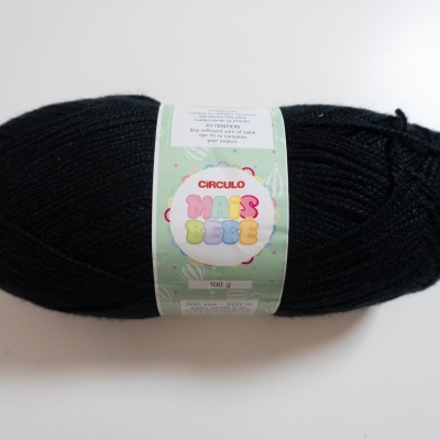 Novelo de lã preto com etiqueta colorida da marca Círculo