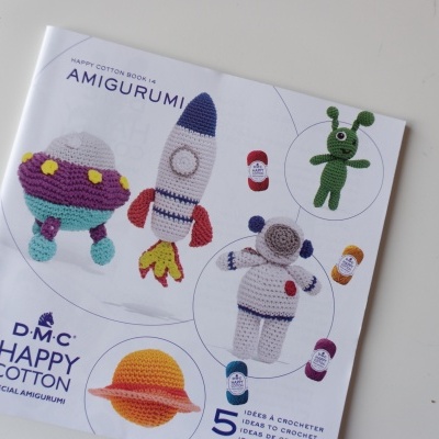 Livro de amigurumi com imagens coloridas de brinquedos feitos de crochê em fundo branco
