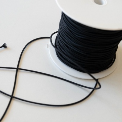 Carretel de fio preto fino em superfície branca