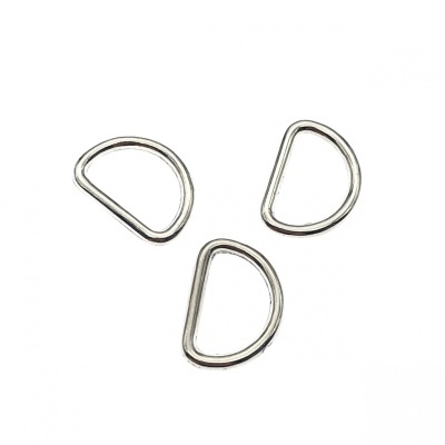 Três argolas metálicas prateadas em formato de meio círculo sobre fundo branco