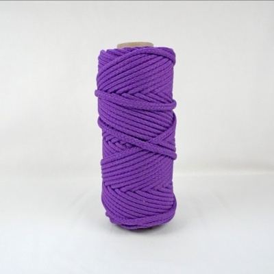 Rolo de corda têxtil roxa enrolada em cilindro sobre fundo branco