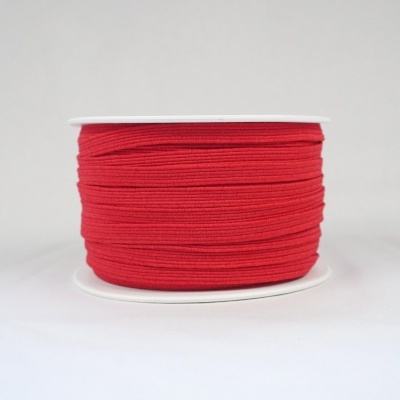 Bobina de elástico vermelho enrolada numa base branca