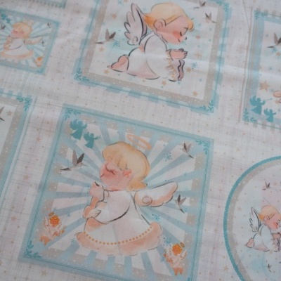 Tecido estampado com padrão de anjos em quadrados azuis e brancos e pequenos detalhes florais e de pássaros.