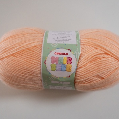 Skein of soft peach yarn with Círculo Mais Bebê label on white background
