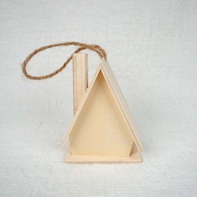 Casinha decorativa de madeira triangular com corda para pendurar sobre fundo branco.
