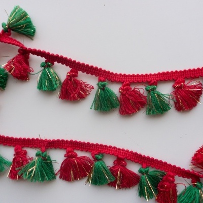 Franja decorativa vermelha, verde e dourada com pompons sobre fundo branco