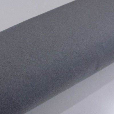 Rolo de tecido cinzento sobre superfície branca