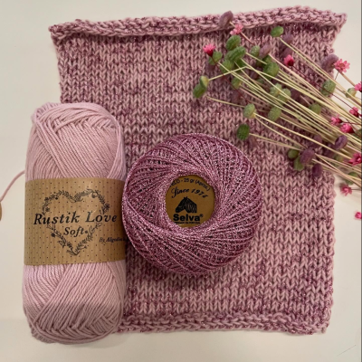 Mostruário de malha cor de malva com novelos de lã rosa e ramo de flores secas