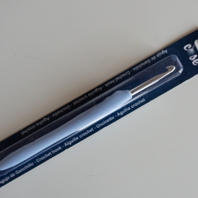 Agulha de croché azul claro em embalagem azul escuro