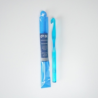 Agulha de crochet azul junto com embalagem plástica transparente em fundo branco