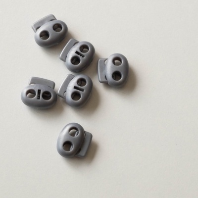 Seis travões de corda cinzentos com dois furos sobre superfície branca