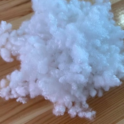 Flocos brancos de enchimento sintético sobre madeira clara