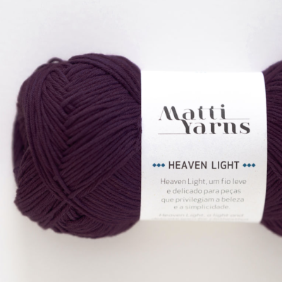Novelo de fio de lã roxo escuro com etiqueta branca da marca Matti Yarns