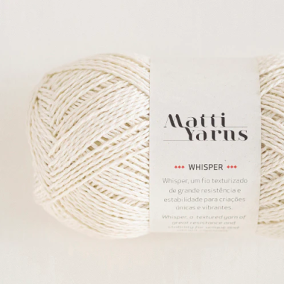 Novelo branco de fio têxtil com etiqueta da marca Matti Yarns e texto Whisper