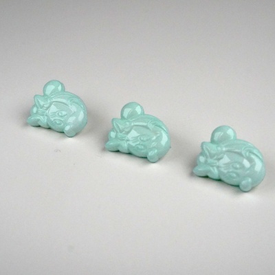 Três brinquedos pequenos em plástico azul claro em forma de gato enrolado.