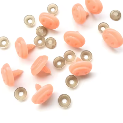 Botões de pressão cor de pêssego com anéis de metal em fundo branco