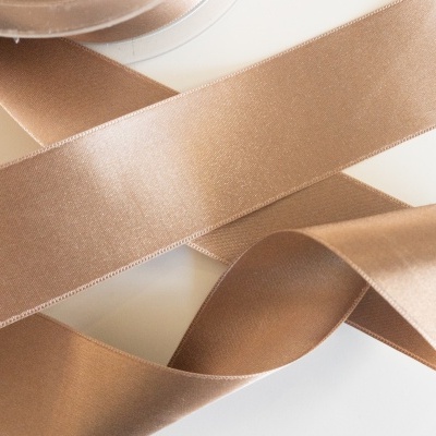 Fita de cetim castanha em rolo, parcialmente desenrolada