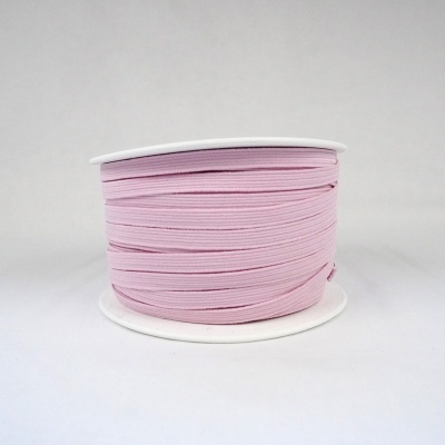 Rolo de fita elástica cor-de-rosa em carretel branco