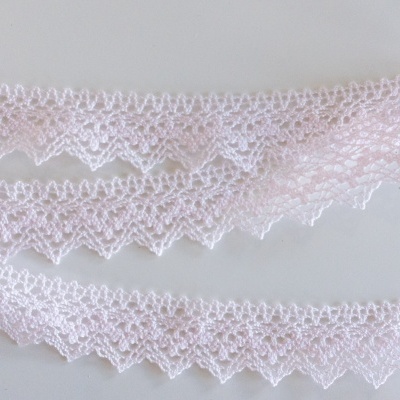 Fitas de renda rosa claro com padrão delicado e bordas em zig-zag sobre fundo branco