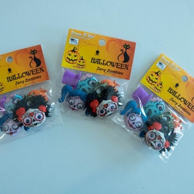 Acessórios de Halloween em embalagem plástica com rótulo amarelo e texto Halloween Zany Zombies.