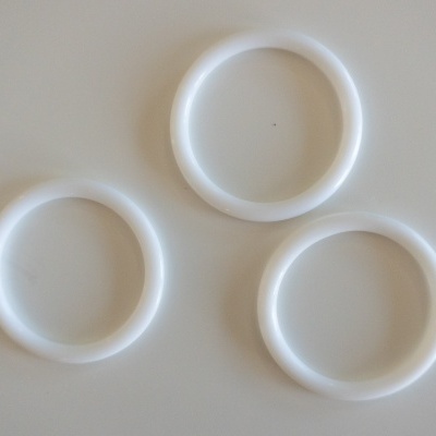Três anéis brancos de plástico sobre fundo branco