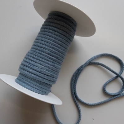 Rolo de cordão azul-acinzentado num carretel branco