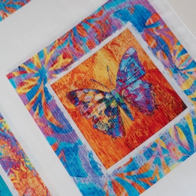 tecido com padrão de borboleta colorida e bordas florais