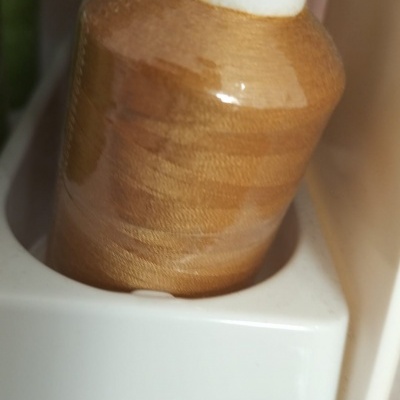 Frasco cor da pele com tampa branca e azul num suporte branco numerado 626