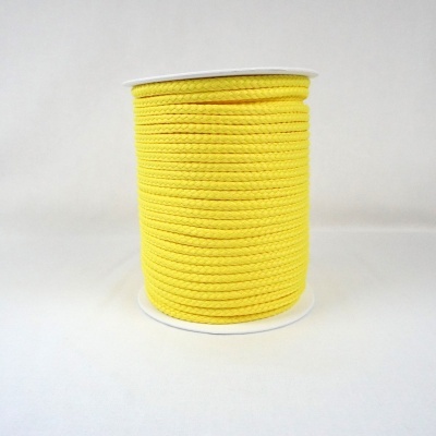 Bobina de cordão amarelo trançado sobre fundo branco