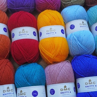 Novelos de lã colorida D.M.C KNITTY 4 organizados lado a lado.
