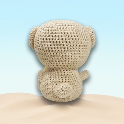 Urso de peluche croche bege visto de costas