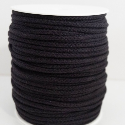 Rolo de cordão preto trançado em suporte branco.