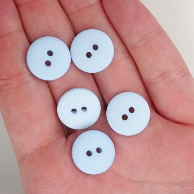 Cinco botões azuis claros redondos com dois furos na palma da mão