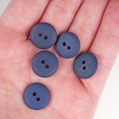 Cinco botões azuis escuros com dois orifícios na mão