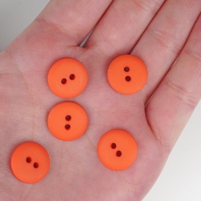Cinco botões laranja em cima de uma mão aberta
