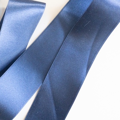 Fitas de cetim azul escuro brilhantes sobre fundo branco